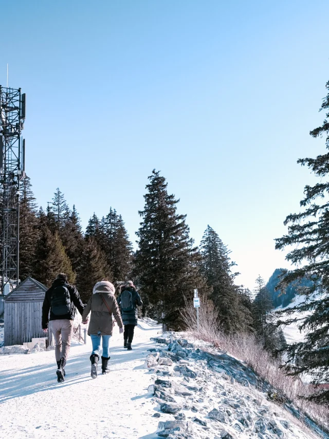 Snowy trail in Thollon Les Memises. A couple stroll hand-in-hand along a snow-covered ridge.