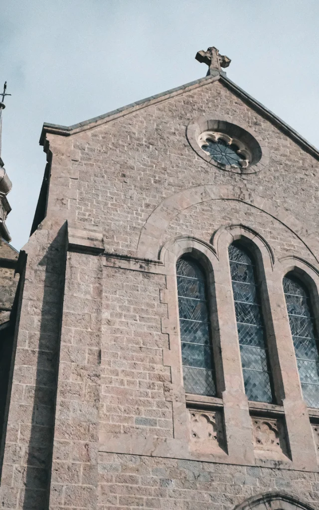 De Abdij van Abondance ligt in het hart van de bergen. Op de foto zie je het voorplein van de abdij, met de enorme gevel van griffonsteen en de imposante glas-in-loodramen aan de voorkant.