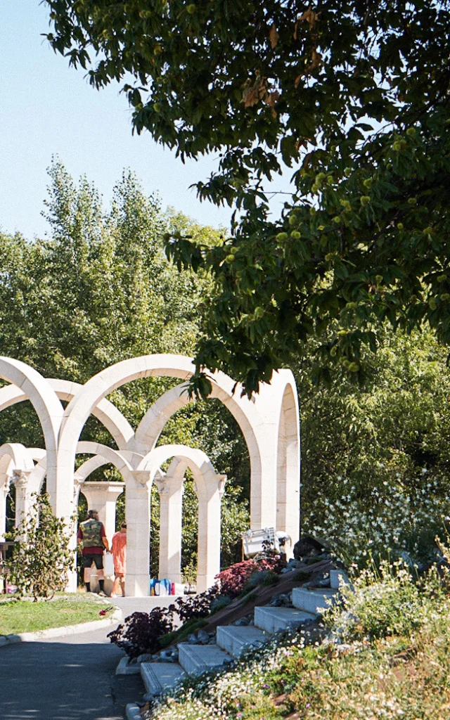 Een bron tussen de bomen gevormd door witte bogen