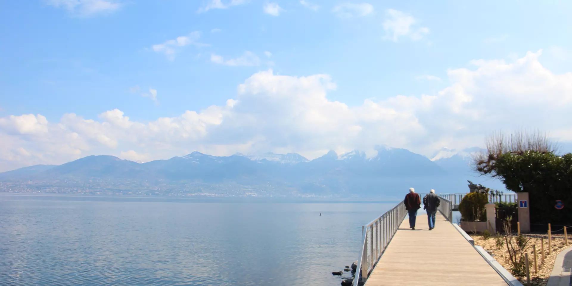 Twee mensen wandelen op een ponton bij het meer