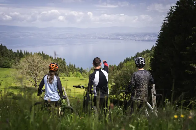 3 personnes à vélo, sur le Plateau de Gavot, avec vue sur le lac