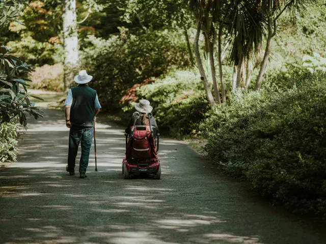 Personne marchant avec une canne et une autre en fauteuil roulant
