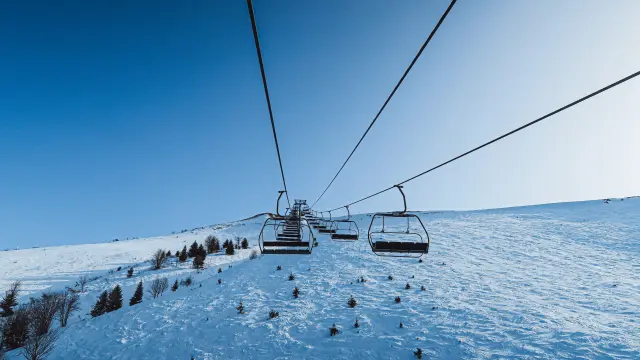 Les remontées mécaniques de Bernex sous la neige et un grand ciel bleu